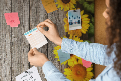 Kork-Pinnwand mit Sonnenblumen auf Holzbrett-Hintergrund