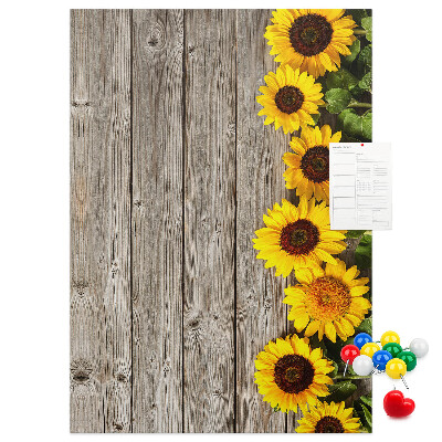 Kork-Pinnwand mit Sonnenblumen auf Holzbrett-Hintergrund