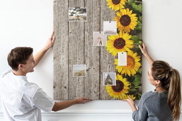 Kork-Pinnwand mit Sonnenblumen auf Holzbrett-Hintergrund