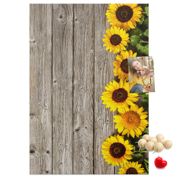Kork-Pinnwand mit Sonnenblumen auf Holzbrett-Hintergrund