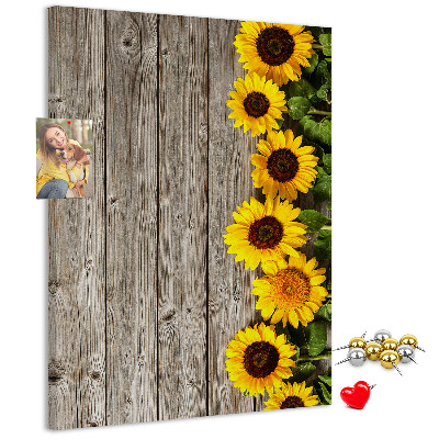 Kork-Pinnwand mit Sonnenblumen auf Holzbrett-Hintergrund