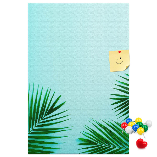 Pinnwand mit tropischen Blättern auf blauem Hintergrund