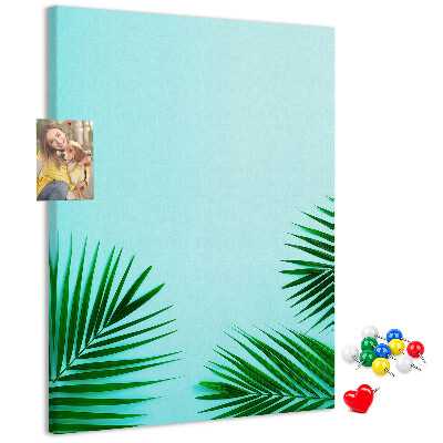 Pinnwand mit tropischen Blättern auf blauem Hintergrund