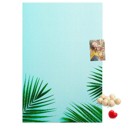 Pinnwand mit tropischen Blättern auf blauem Hintergrund