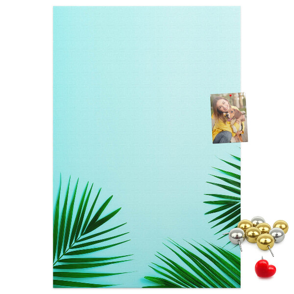 Pinnwand mit tropischen Blättern auf blauem Hintergrund