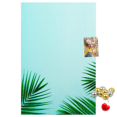 Pinnwand mit tropischen Blättern auf blauem Hintergrund