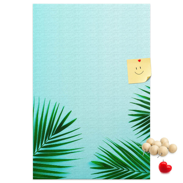 Pinnwand mit tropischen Blättern auf blauem Hintergrund