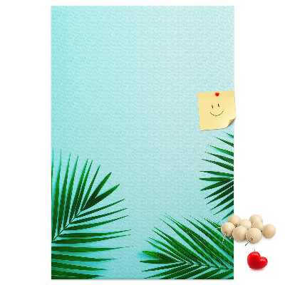 Pinnwand mit tropischen Blättern auf blauem Hintergrund