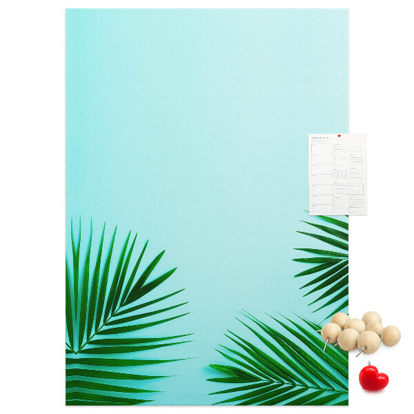 Pinnwand mit tropischen Blättern auf blauem Hintergrund