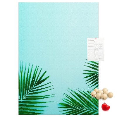 Pinnwand mit tropischen Blättern auf blauem Hintergrund