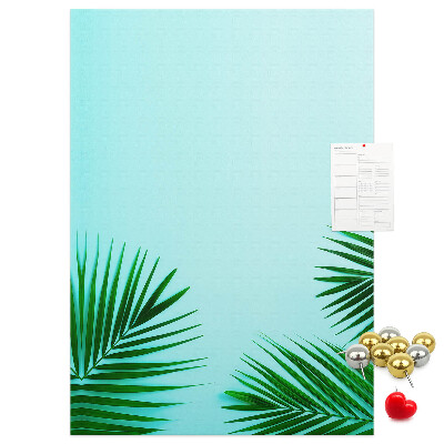 Pinnwand mit tropischen Blättern auf blauem Hintergrund