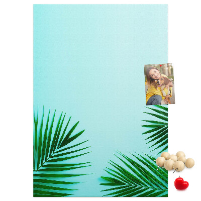 Pinnwand mit tropischen Blättern auf blauem Hintergrund