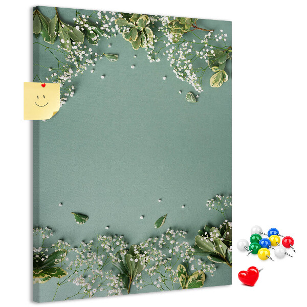Pinnwand mit grünem Hintergrund, zarten Blüten und Blättern