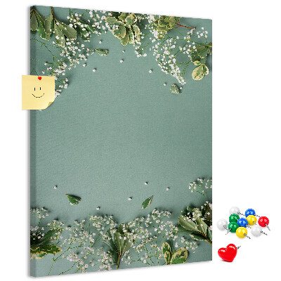 Pinnwand mit grünem Hintergrund, zarten Blüten und Blättern