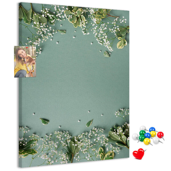 Pinnwand mit grünem Hintergrund, zarten Blüten und Blättern
