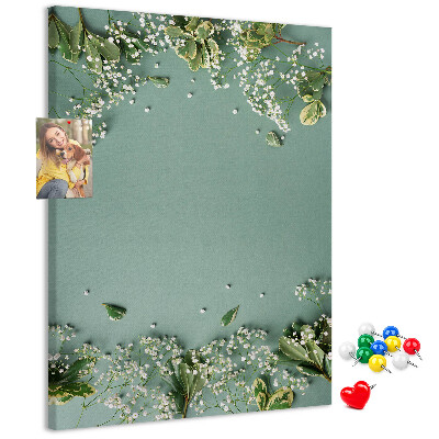 Pinnwand mit grünem Hintergrund, zarten Blüten und Blättern