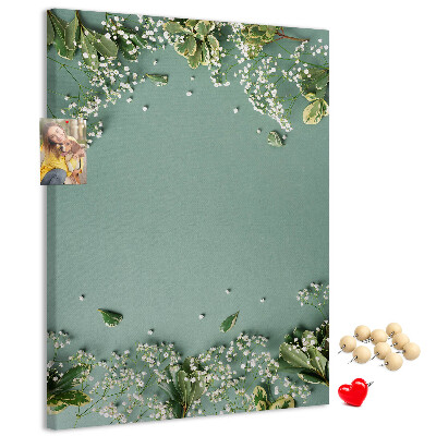 Pinnwand mit grünem Hintergrund, zarten Blüten und Blättern