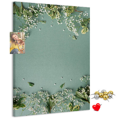 Pinnwand mit grünem Hintergrund, zarten Blüten und Blättern