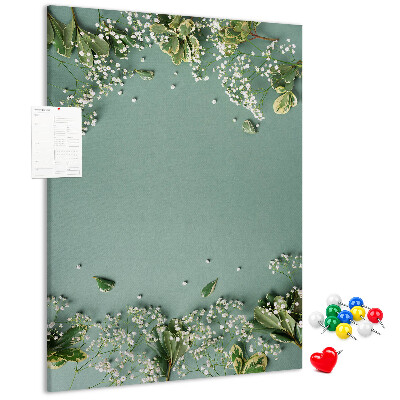 Pinnwand mit grünem Hintergrund, zarten Blüten und Blättern