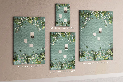 Pinnwand mit grünem Hintergrund, zarten Blüten und Blättern