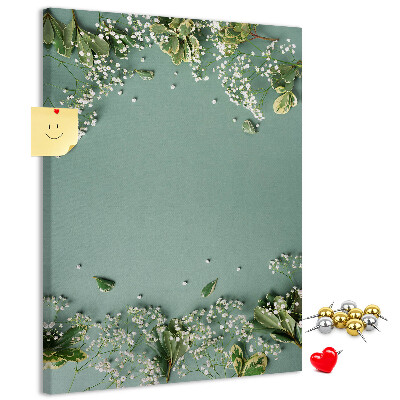Pinnwand mit grünem Hintergrund, zarten Blüten und Blättern