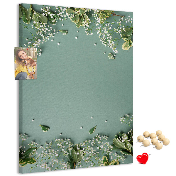 Pinnwand mit grünem Hintergrund, zarten Blüten und Blättern