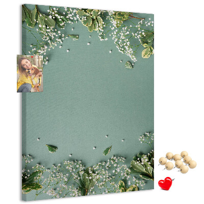 Pinnwand mit grünem Hintergrund, zarten Blüten und Blättern