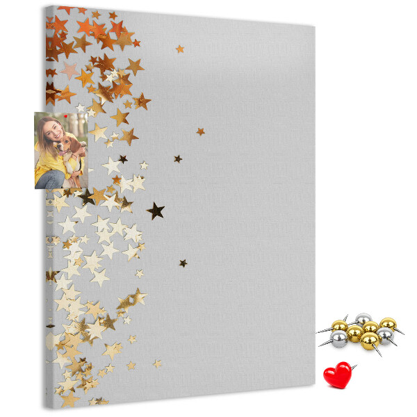 Pinnwand mit goldenen und silbernen Sternen auf grauem Grund