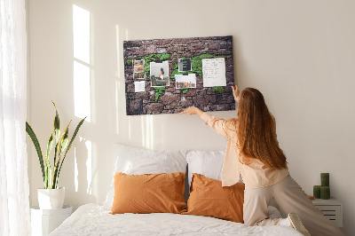 Korktafel mit Motiv einer grünen Weltkarte auf einer Steinmauer
