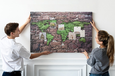 Korktafel mit Motiv einer grünen Weltkarte auf einer Steinmauer