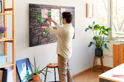 Korktafel mit Motiv einer grünen Weltkarte auf einer Steinmauer
