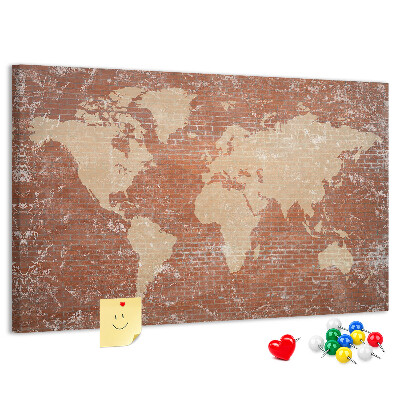 Korktafel mit Weltkartenmotiv vor einer Backsteinmauer