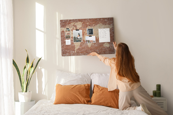 Korktafel mit Weltkartenmotiv vor einer Backsteinmauer