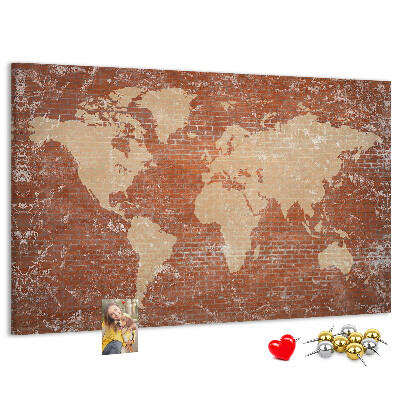 Korktafel mit Weltkartenmotiv vor einer Backsteinmauer