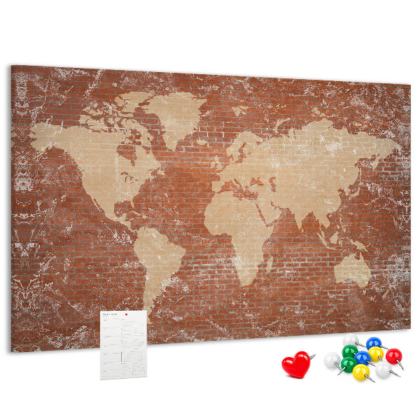 Korktafel mit Weltkartenmotiv vor einer Backsteinmauer