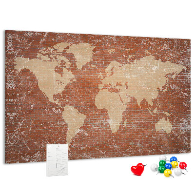 Korktafel mit Weltkartenmotiv vor einer Backsteinmauer