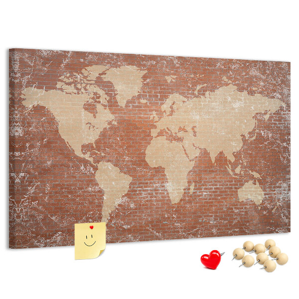 Korktafel mit Weltkartenmotiv vor einer Backsteinmauer