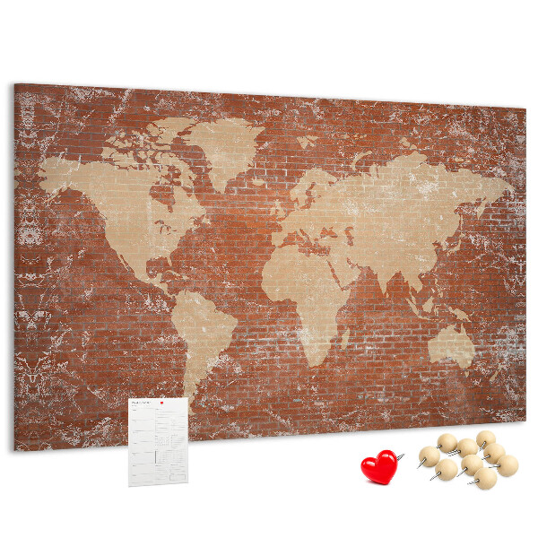 Korktafel mit Weltkartenmotiv vor einer Backsteinmauer