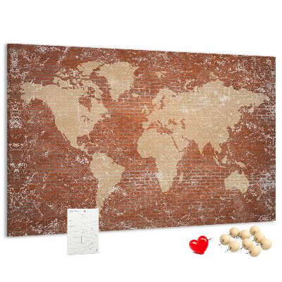 Korktafel mit Weltkartenmotiv vor einer Backsteinmauer