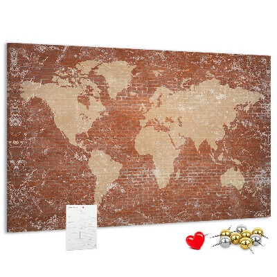 Korktafel mit Weltkartenmotiv vor einer Backsteinmauer