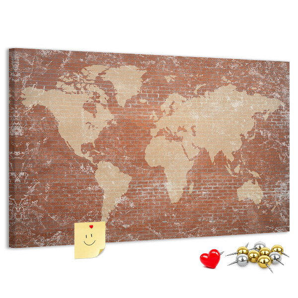 Korktafel mit Weltkartenmotiv vor einer Backsteinmauer