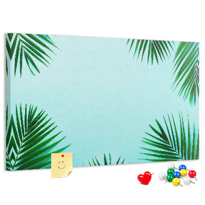 Korktafel mit tropischen Blättern auf blauem Hintergrund