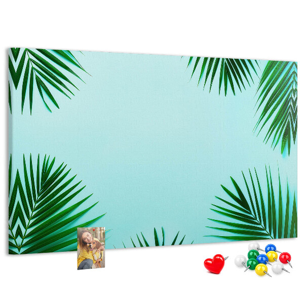 Korktafel mit tropischen Blättern auf blauem Hintergrund