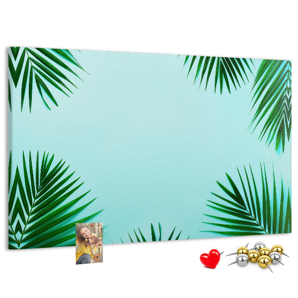 Korktafel mit tropischen Blättern auf blauem Hintergrund