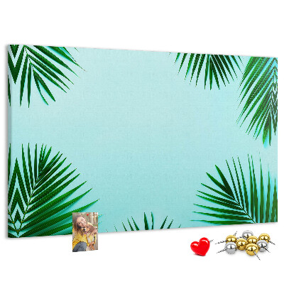 Korktafel mit tropischen Blättern auf blauem Hintergrund
