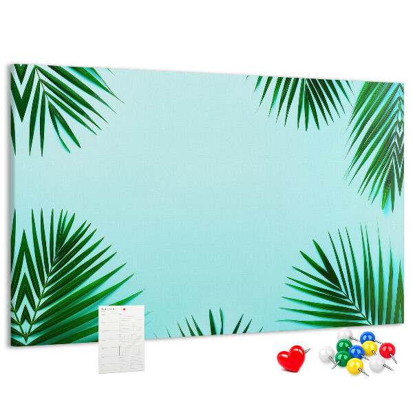 Korktafel mit tropischen Blättern auf blauem Hintergrund