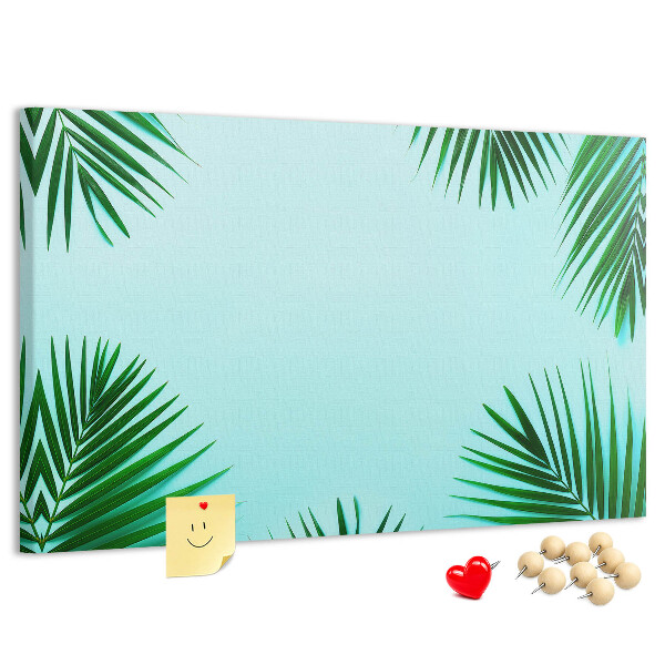 Korktafel mit tropischen Blättern auf blauem Hintergrund