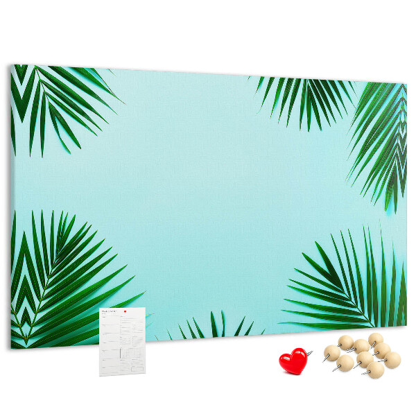 Korktafel mit tropischen Blättern auf blauem Hintergrund