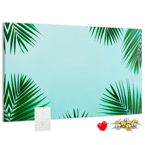 Korktafel mit tropischen Blättern auf blauem Hintergrund
