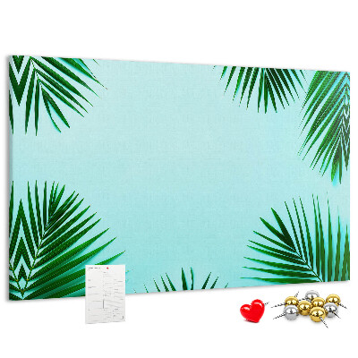 Korktafel mit tropischen Blättern auf blauem Hintergrund